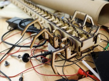 A complex wooden contraption with gears and wires.