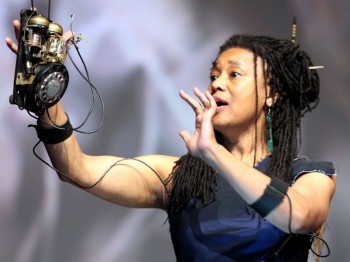 A woman performs while holding parts of a rotary phone.