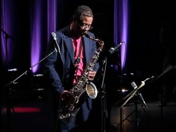 A man performs saxophone on stage