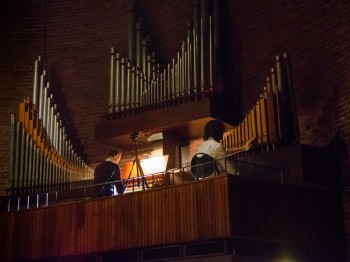 Two people playing an organ.