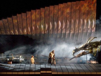 A performer holding a spear faces off with a large dragon head