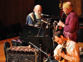 A guitarist, clarinetist, and pianist perform.