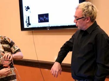 A student and a visiting artist talk in a music class.