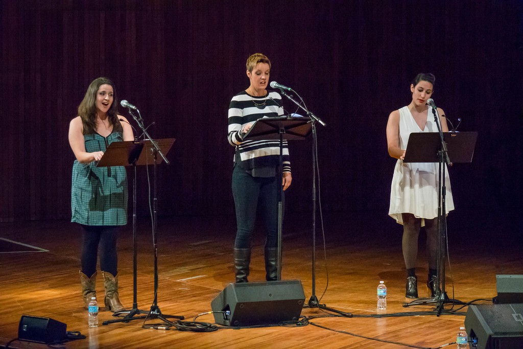 Three singers perform on stage.