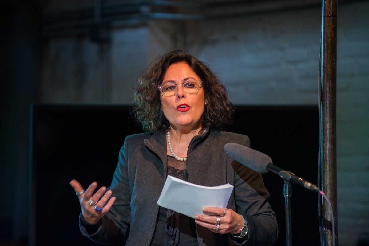 A woman speaks into a microphone