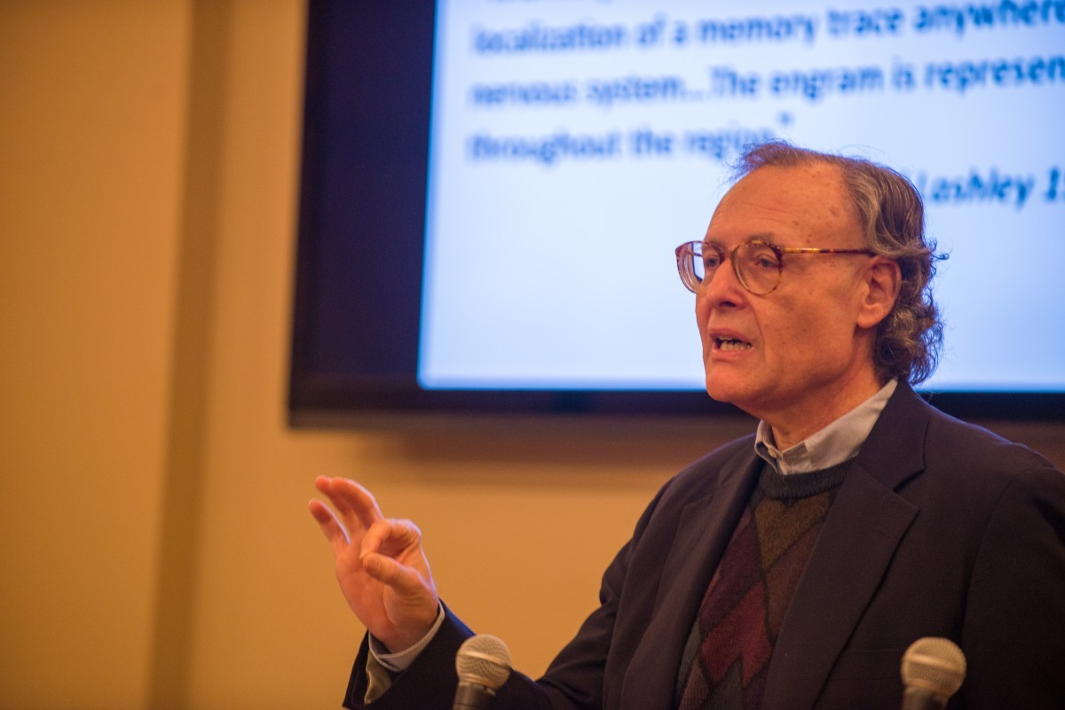 A man speaks at a symposium.