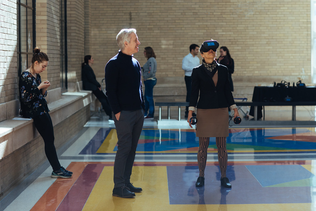 People walking in large room with headsets