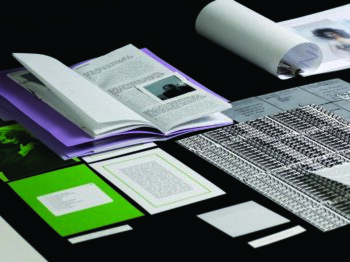 A selection of printed paper materials laid out on a black table