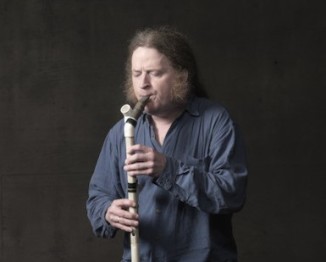 Mark Stewart plays a homemade wind instrument.